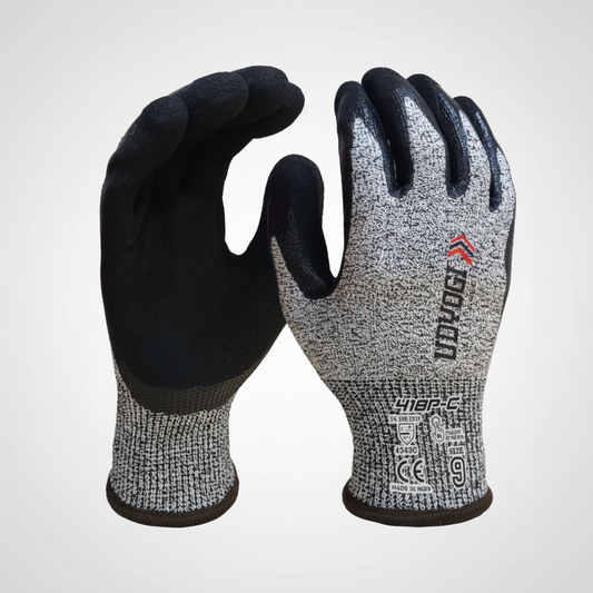 A pair of heavy-duty work gloves shown from both sides. The left glove shows the black foam-polyester palm and fingers, while the right glove shows the gray knit back with black grip coating, a red logo, and safety certification labels on the cuff.